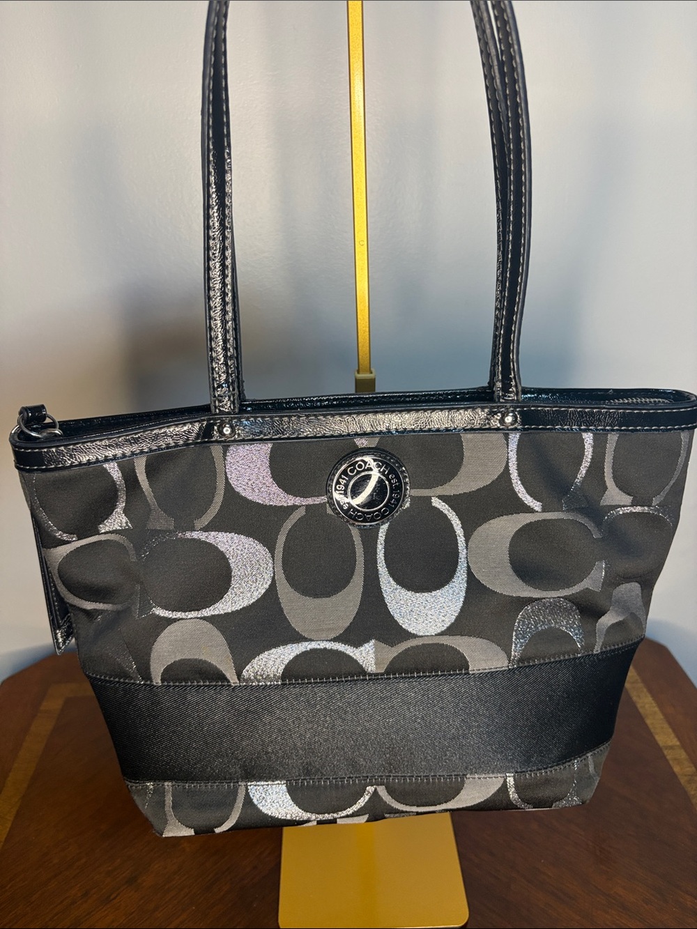 This is a Coach Signature Tote Bag in black and silver.